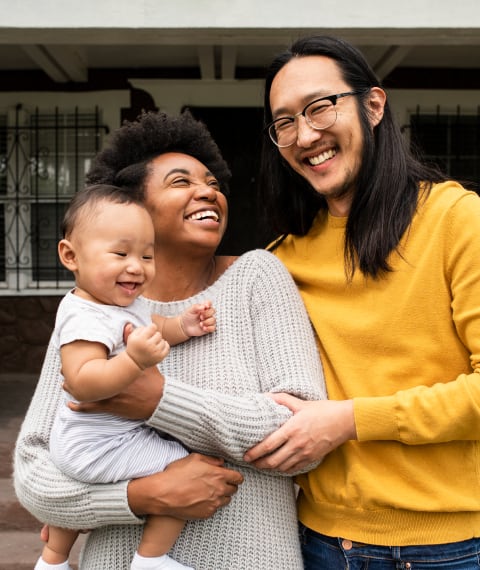 Family smiling and holding their child