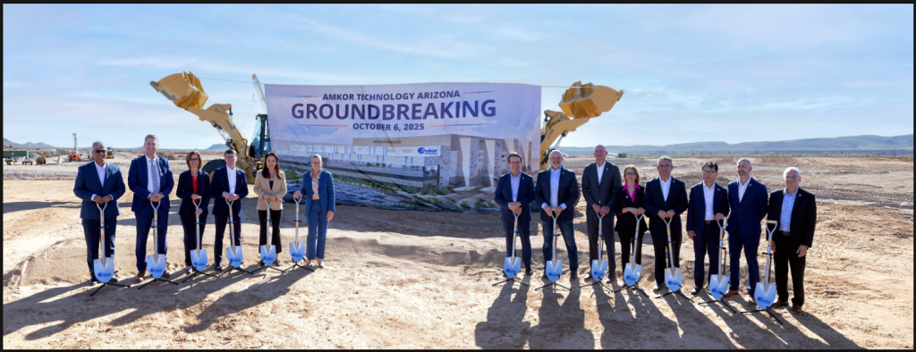 Group photo of Amkor Technology executives and partners standing with shovels at the Peoria, Arizona semiconductor facility groundbreaking event, with construction equipment and a large "Groundbreaking October 6, 2025" banner in the background.